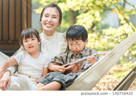 Family playing in a hammock at a campsite, Family (outdoors, travel, leisure, picnic) 130758420