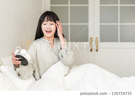 年輕的亞洲女性看到鬧鐘時感到驚訝和驚訝(睡過頭、遲到、睡過頭) 年輕的亞洲女性看到鬧鐘時感到驚訝和驚訝(睡過頭、遲到、睡過頭) 130759735