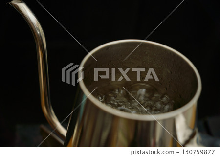 滴濾壺裡的水沸騰了。一系列照片展示了使用紙滴濾壺沖泡咖啡的過程。 滴濾壺裡的水沸騰了。一系列照片展示了使用紙滴濾壺沖泡咖啡的過程。 130759877