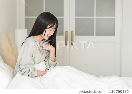 Unwell woman with a cold coughing in bed 130760185