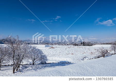 Winter scenery seen from a snowy hill Winter scenery seen from a snowy hill 130760385