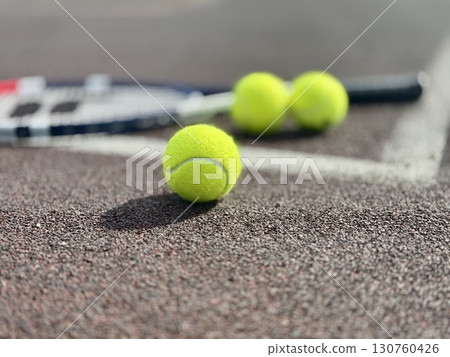 yellow tennis balls are lying on the tennis court along with a racket. High quality photo 130760426
