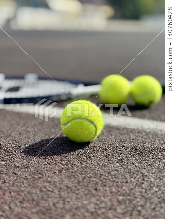 yellow tennis balls are lying on the tennis court along with a racket. High quality photo yellow tennis balls are lying on the tennis court along with a racket. High quality photo 130760428