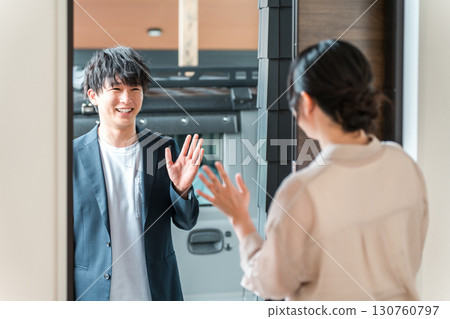 一位年輕的亞洲女性/妻子早上在前門送別去上班的丈夫 130760797