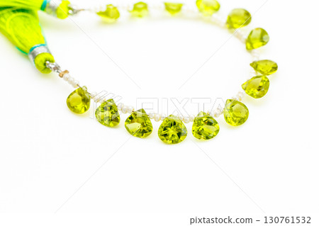Peridot bead strands and tassels against a white background 130761532
