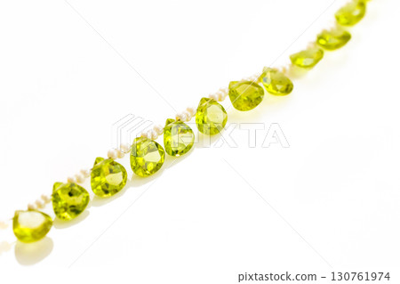 白色背景下的橄欖石珠串和流蘇 130761974