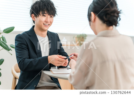 年輕的亞洲商人在談判桌上與女性客戶會面、諮詢和聽取意見 130762644