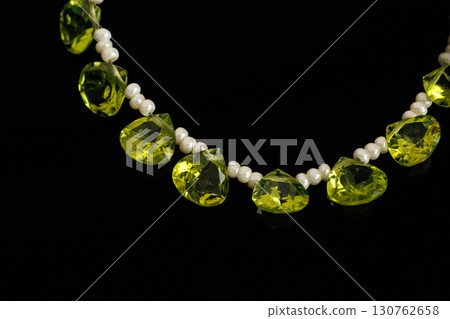 橢圓形切割的橄欖石和珍珠在黑色背景下格外醒目 130762658