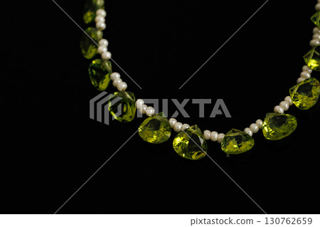 Briolette-cut loose peridot and pearls that stand out against a black background Briolette-cut loose peridot and pearls that stand out against a black background 130762659