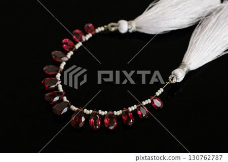 Rhodolite garnet and pearl briolette cut loose stones that stand out against a black background Rhodolite garnet and pearl briolette cut loose stones that stand out against a black background 130762787