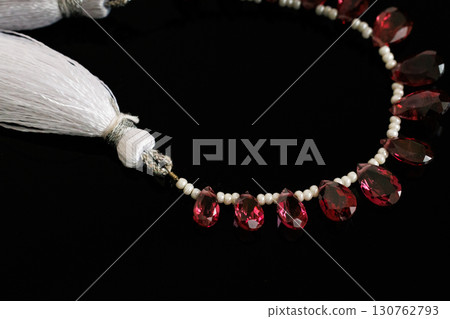Rhodolite garnet and pearl briolette cut loose stones that stand out against a black background Rhodolite garnet and pearl briolette cut loose stones that stand out against a black background 130762793
