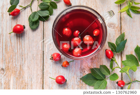 Rosehip tea brewing in glass cup on rustic wooden table Rosehip tea brewing in glass cup on rustic wooden table 130762960