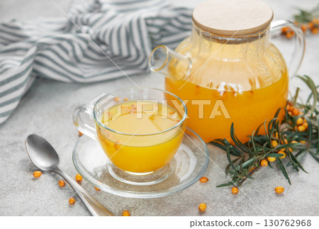 Sea buckthorn tea with fresh berries and a teapot on table 130762968