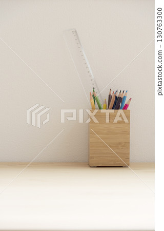 Wooden pen holder and writing implements on a wooden desk Wooden pen holder and writing implements on a wooden desk 130763300
