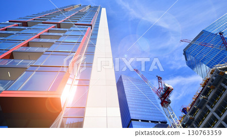 Exterior of a high modern multi-story apartment building - facade, windows and balconies. Timeless glass facade. Modern urban living district. Exterior of a high modern multi-story apartment building - facade, windows and balconies. Timeless glass facade. Modern urban living district. 130763359
