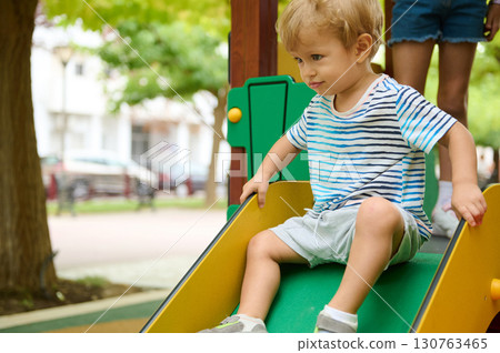 Adventures of a Child Sliding at a Park on a Sunny Day 130763465