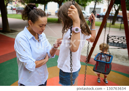 Mother and Children Playing Together in a Colorful Playground Setting 130763634