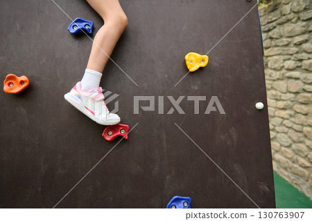 Climbing Activity on an Outdoor Rock Training Wall with Colorful Holds 130763907