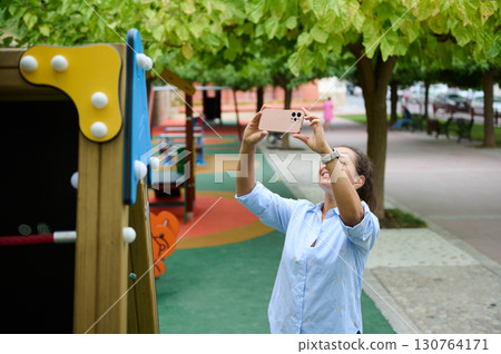 Woman Taking a Picture in a Vibrant Urban Playground Woman Taking a Picture in a Vibrant Urban Playground 130764171