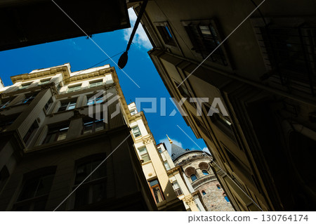 Istanbul, Turkey. View of Galata tower through the streets with tight buildings. Travel attraction. Islamic architecture Istanbul, Turkey. View of Galata tower through the streets with tight buildings. Travel attraction. Islamic architecture 130764174