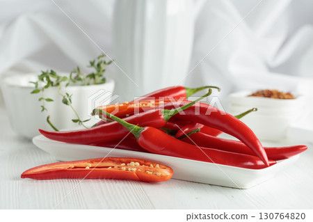 Fresh red chili peppers with on a white wooden table. 130764820