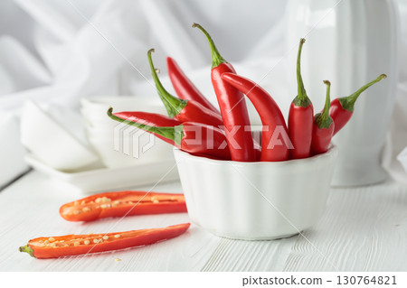 Fresh red chili peppers with on a white wooden table. 130764821