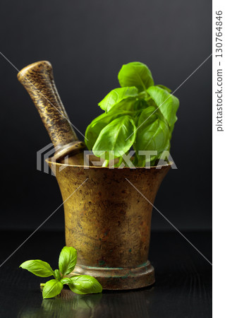 Vintage brass mortar with sprig of basil. Vintage brass mortar with sprig of basil. 130764846