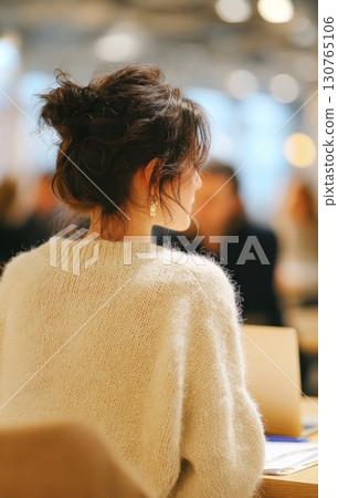 Businesswoman sitting at desk listening during conference meeting 130765106