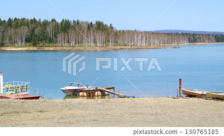A boat floating on a lake A boat floating on a lake 130765185