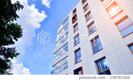 European residential architecture harmonizing with nature. Eco-friendly living in city with greens. Eco apartment building saving energy and fresh air concept.  130765369