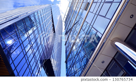 Modern sustainable glass office buildings. Exterior view of corporate headquarters glass buildings architecture.Glass windows in energy-efficient buildings. Financial business center buildings.  130765734
