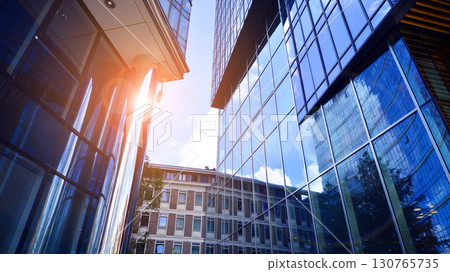 Modern sustainable glass office buildings. Exterior view of corporate headquarters glass buildings architecture.Glass windows in energy-efficient buildings. Financial business center buildings.  130765735