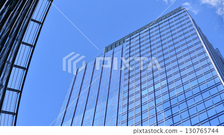 Modern sustainable glass office buildings. Exterior view of corporate headquarters glass buildings architecture.Glass windows in energy-efficient buildings. Financial business center buildings.  130765744