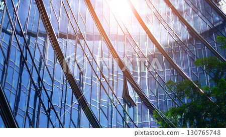 Modern sustainable glass office buildings. Exterior view of corporate headquarters glass buildings architecture.Glass windows in energy-efficient buildings. Financial business center buildings.  130765748