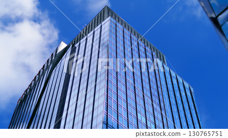 Modern sustainable glass office buildings. Exterior view of corporate headquarters glass buildings architecture.Glass windows in energy-efficient buildings. Financial business center buildings.  130765751