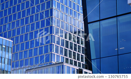 Modern sustainable glass office buildings. Exterior view of corporate headquarters glass buildings architecture.Glass windows in energy-efficient buildings. Financial business center buildings. Modern sustainable glass office buildings. Exterior view of corporate headquarters glass buildings architecture.Glass windows in energy-efficient buildings. Financial business center buildings. 130765755