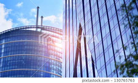 Modern sustainable glass office buildings. Exterior view of corporate headquarters glass buildings architecture.Glass windows in energy-efficient buildings. Financial business center buildings. Modern sustainable glass office buildings. Exterior view of corporate headquarters glass buildings architecture.Glass windows in energy-efficient buildings. Financial business center buildings. 130765763
