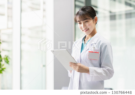 A young female doctor operating a tablet A young female doctor operating a tablet 130766448