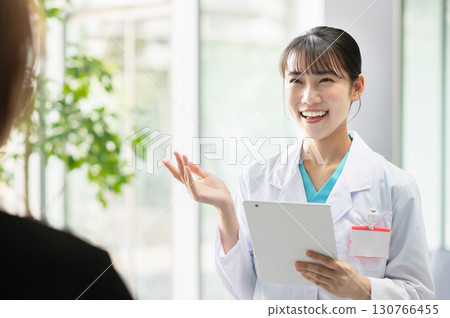 一位年輕的女醫生正在檢查病人 130766455