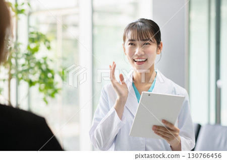一位年輕的女醫生正在檢查病人 一位年輕的女醫生正在檢查病人 130766456