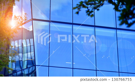 Sustainable glass office building with trees for reducing carbon dioxide. Eco-friendly building in modern city. Office with green environment. Corporate building reduce CO2. 130766755
