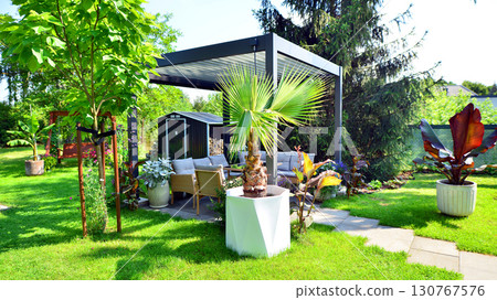 Modern aluminum pergola with stylish garden furniture in a beautiful garden. Modern aluminum pergola with stylish garden furniture in a beautiful garden. 130767576