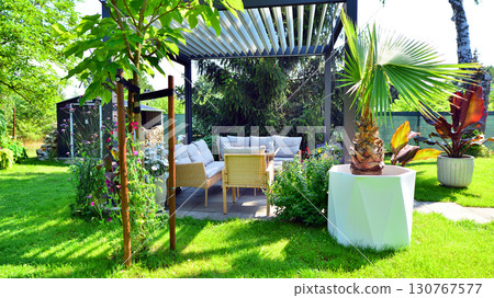 Modern aluminum pergola with stylish garden furniture in a beautiful garden. Modern aluminum pergola with stylish garden furniture in a beautiful garden. 130767577