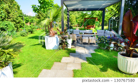 Modern aluminum pergola with stylish garden furniture in a beautiful garden. Modern aluminum pergola with stylish garden furniture in a beautiful garden. 130767580