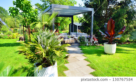 Modern aluminum pergola with stylish garden furniture in a beautiful garden. Modern aluminum pergola with stylish garden furniture in a beautiful garden. 130767584