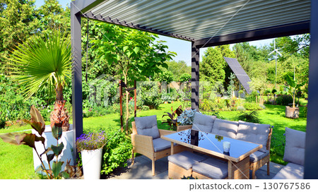 Modern aluminum pergola with stylish garden furniture in a beautiful garden. Modern aluminum pergola with stylish garden furniture in a beautiful garden. 130767586