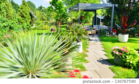 Modern aluminum pergola with stylish garden furniture in a beautiful garden. Modern aluminum pergola with stylish garden furniture in a beautiful garden. 130767590