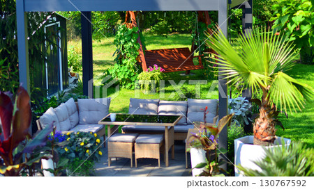Modern aluminum pergola with stylish garden furniture in a beautiful garden. Modern aluminum pergola with stylish garden furniture in a beautiful garden. 130767592