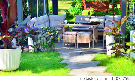 Modern aluminum pergola with stylish garden furniture in a beautiful garden. 130767593