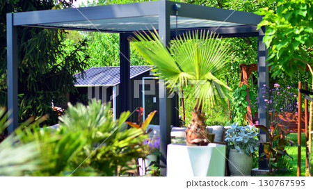 Modern aluminum pergola with stylish garden furniture in a beautiful garden. Modern aluminum pergola with stylish garden furniture in a beautiful garden. 130767595